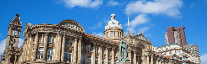 This is a photo of the Victoria Square in Birmingham, England, a statue of Queen Victoria stands in front of the council house.